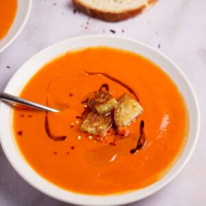 An overhead shot of this pureed healthy tomato soup recipe made croutons on top. 