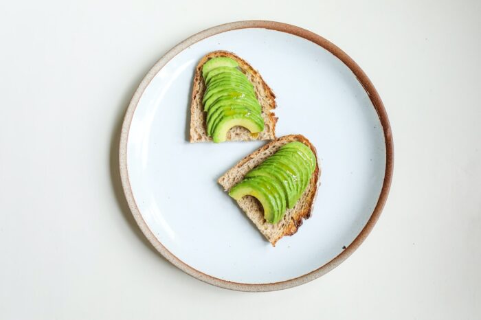 Avocado toast on white plate, birds eye view.