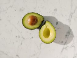 Avocado cut in half on countertop.