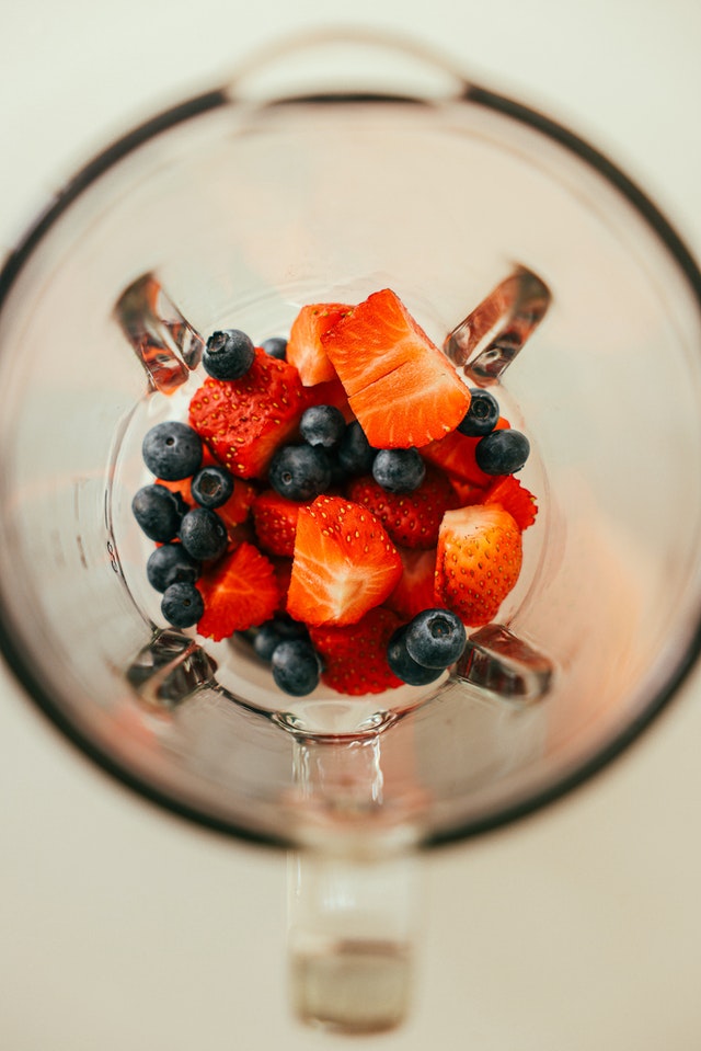 Overhead view of inside blender with berries inside.